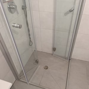 מקלחון פינתי עם דלתות זכוכית פתוחות