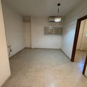 חדר ריק עם רצפת אריחים, חלון ומזגן