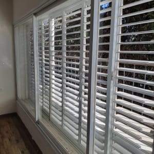 תריסים לבנים עם אבק על אדן החלון