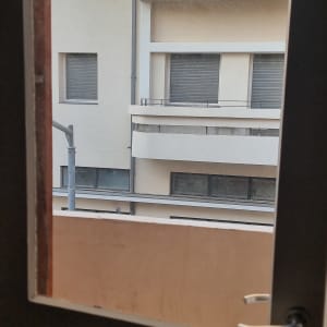 חלון זכוכית פתוח עם נוף לבניין ממול