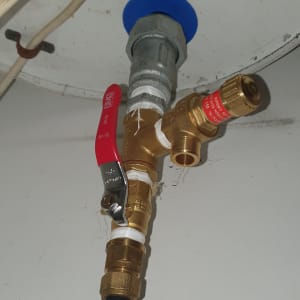 שסתום פליז עם ידית אדומה וצינור מחובר