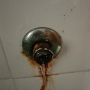 ברז דולף עם חלודה על הקיר