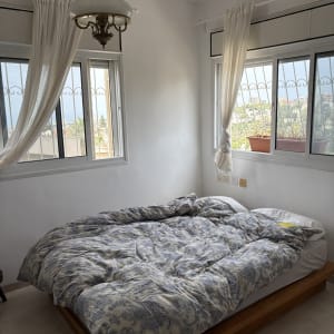 חדר שינה עם מיטה, חלונות ווילונות לבנים