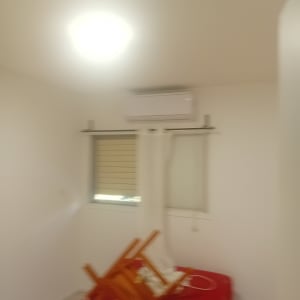 חדר עם קירות לבנים ומזגן על הקיר