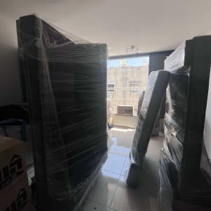 רהיטים עטופים בניילון מוכנים להובלה בחדר מואר