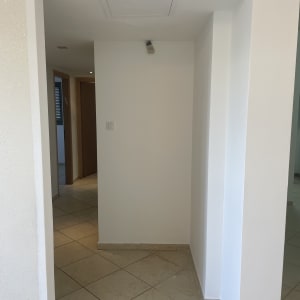 קיר צבוע בלבן עם רצפת אריחים