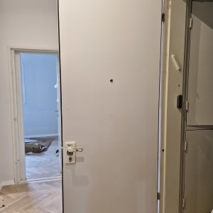 דלת לבנה עם ידית ומנעול מותקנים