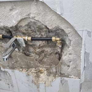 צנרת חשופה בקיר עם ברז מותקן