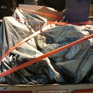 משאית עם כיסוי ברזנט וציוד קשור ברצועות כתומות