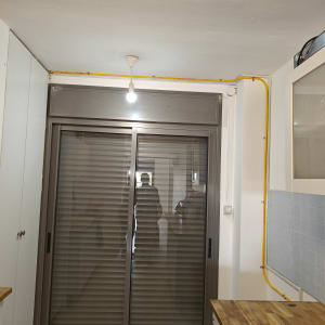 צינור גז צהוב מותקן על הקיר ליד חלון