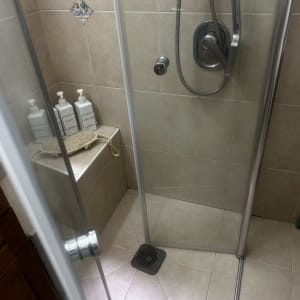 מקלחת עם דלת זכוכית, ראש מקלחת וסבונים