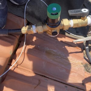 שסתום פליז עם ידית שחורה על גג רעפים