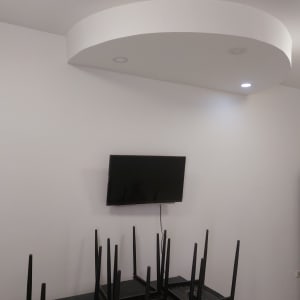 קיר לבן עם טלוויזיה תלויה ותקרה מעוצבת