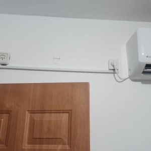 שקע חשמל ליד מזגן על קיר לבן