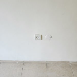 קיר צבוע בלבן עם שקע חשמל