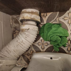 צינור לבן עם מטלית ירוקה על רצפה מעוצבת