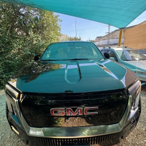 רכב GMC שחור תחת סככה כחולה