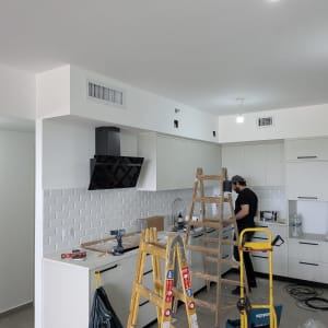 מטבח עם איש מקצוע וסולם בעבודת התקנה