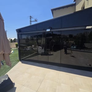 מבנה עם קירות זכוכית בחצר חיצונית
