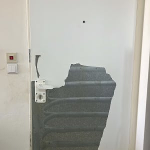 דלת עם ציפוי מתקלף בחלקה התחתון