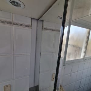 קיר אריחים עם מסגרת חלון וזכוכית מט