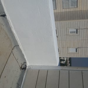 גג עם קיר לבן ורצפת אריחים אפורה