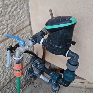 ברז מים עם צינור ירוק ומחבר פלסטיק