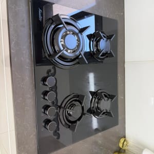 כיריים גז שחורות עם כפתורים במטבח מודרני