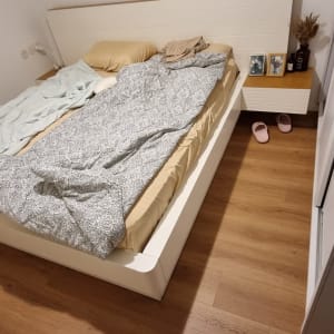 רצפת פרקט בחדר שינה עם מיטה מסודרת