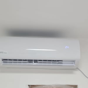 מזגן קיר לבן עם תצוגת טמפרטורה 24 מעלות