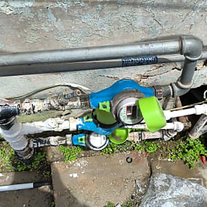 מונה מים וצנרת חיצונית על קיר בניין