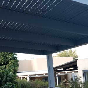 פרגולה מעץ בגינה עם צמחייה מסביב