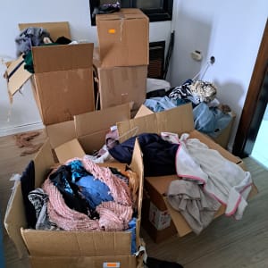 קופסאות קרטון מלאות בבגדים בחדר