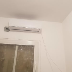 מזגן מותקן על קיר מעל חלון