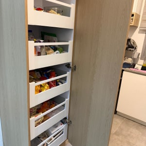 ארון מטבח פתוח עם מדפים מלאים במוצרים שונים