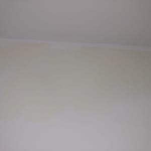 קיר צבוע בגוון בהיר עם סימני צבע שונים