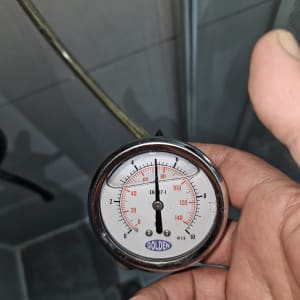 מד לחץ עם מחוג, יד מחזיקה את המכשיר