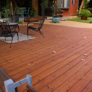 דק עץ עם כיסאות מתכת ושולחן קטן