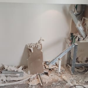 קיר גבס שבור עם חוטי חשמל וכלי עבודה