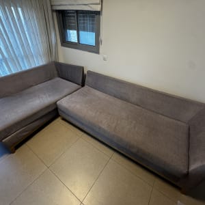 ספות אפורות בחדר עם חלון ווילון לבן