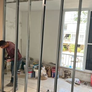 אדם עובד על קיר גבס בחדר במהלך שיפוץ