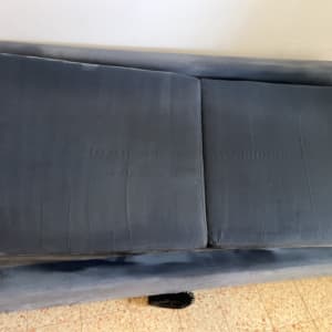 ספה כחולה עם כריות על רצפה