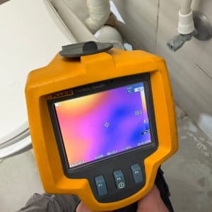 מד חום תרמי משמש לבדיקה ליד צנרת בשירותים