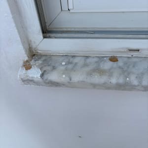 אדן חלון עם סימני צבע ולכלוך