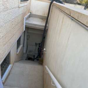 צינור יניקה של משאית ואקום יורד במדרגות