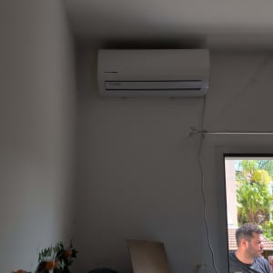 מזגן מותקן על קיר עם כבל חשמל מחובר