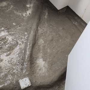 רצפה עם חומר איטום ליד אסלה בחדר אמבטיה