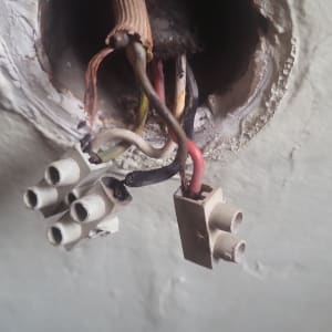 חוטי חשמל חשופים עם מחברים בקיר