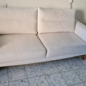 ספה בהירה על רצפת אריחים