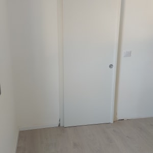 דלת הזזה לבנה על קיר לבן